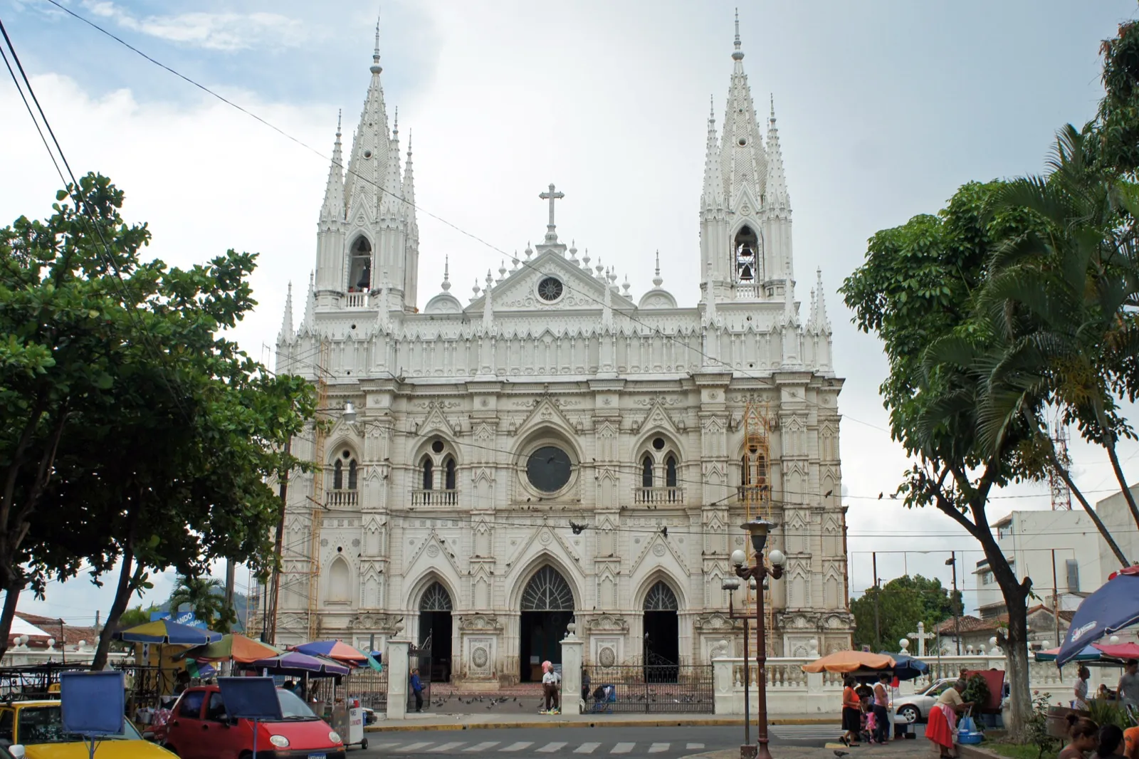 Fachada neogótica de la Catedral de Santa Ana, El Salvador, vista desde la calle entre árboles